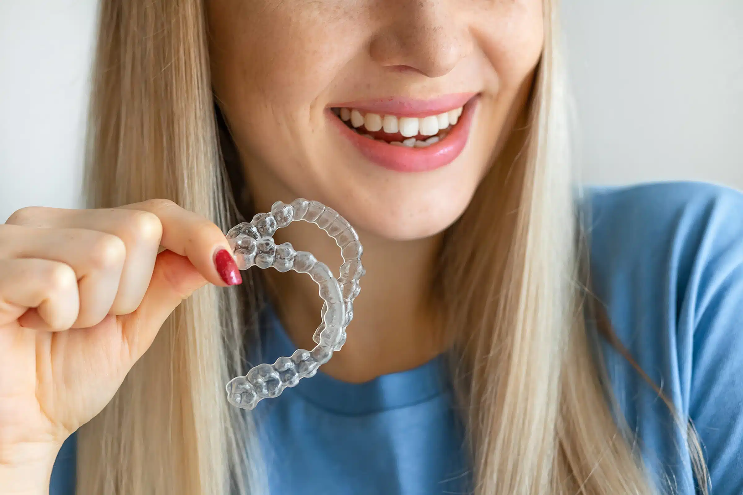 A clear aligner held up before wear