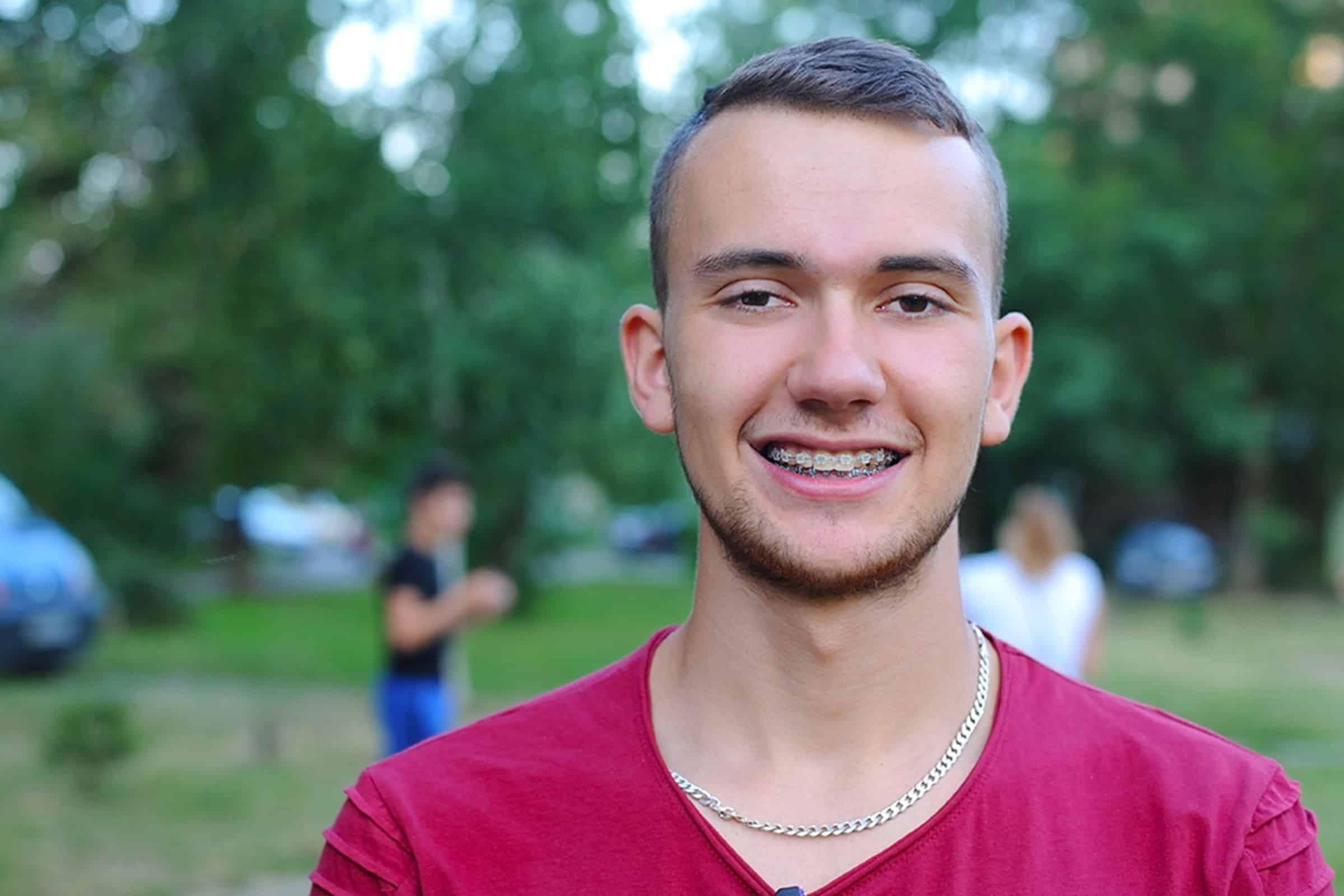 Young man smiling with ceramic braces in Midland, TX